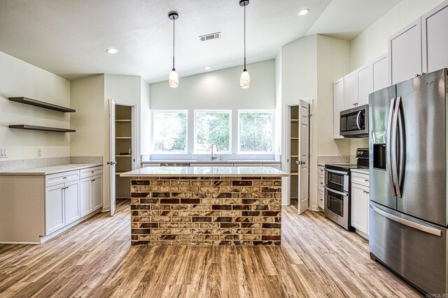 kitchen featuring appliances with stainless steel finishes, visible vents, light wood finished floors, and open shelves