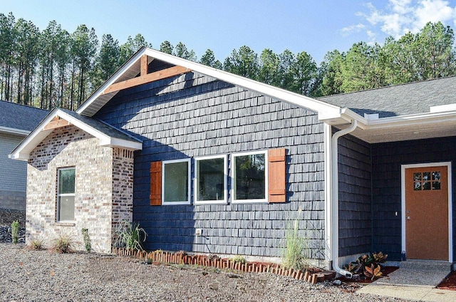 view of property exterior with roof with shingles