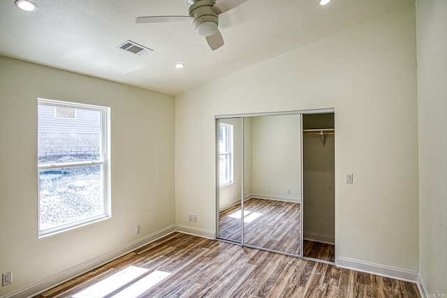 unfurnished bedroom featuring visible vents, wood finished floors, vaulted ceiling, a closet, and recessed lighting
