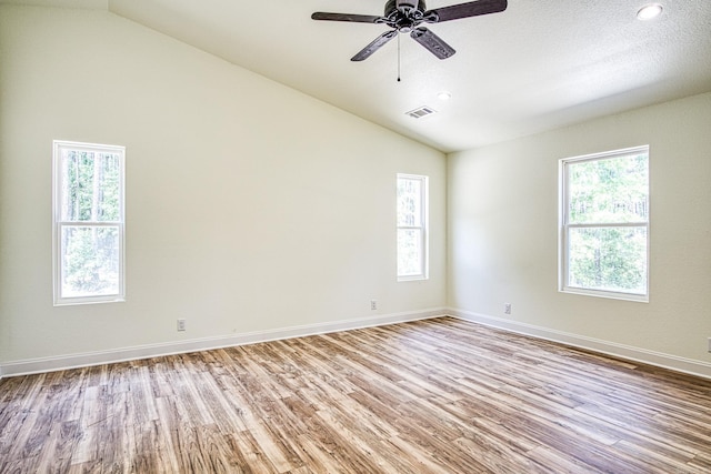 spare room with lofted ceiling, plenty of natural light, and wood finished floors