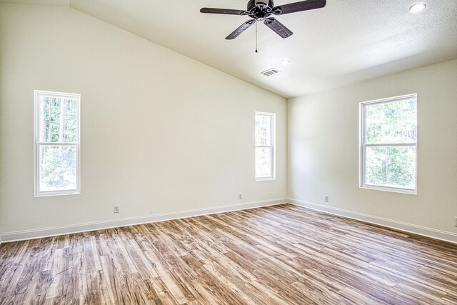 spare room featuring a textured ceiling, ceiling fan, vaulted ceiling, and light hardwood / wood-style floors