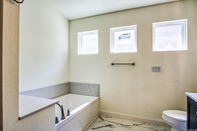 full bath featuring baseboards, toilet, marble finish floor, a garden tub, and vanity