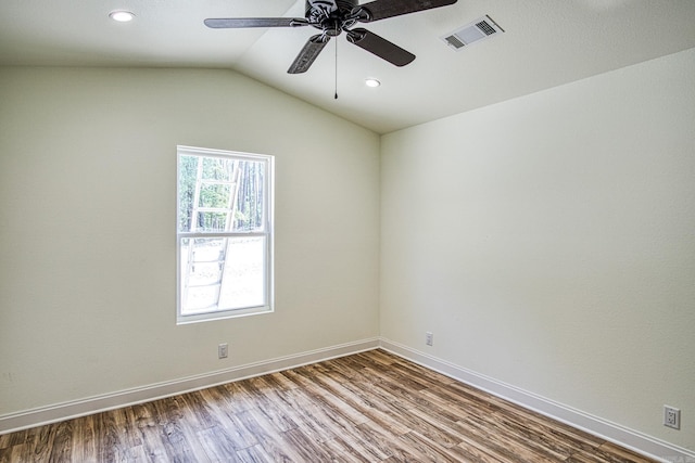 unfurnished room with lofted ceiling, recessed lighting, wood finished floors, visible vents, and baseboards
