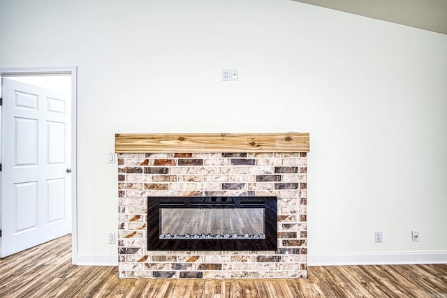 details with a brick fireplace, baseboards, and wood finished floors