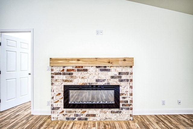 room details with wood-type flooring and a brick fireplace