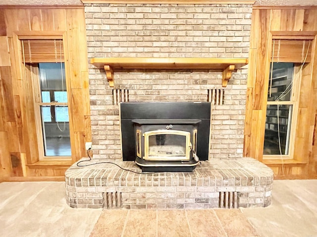 interior details featuring a wood stove and wood walls