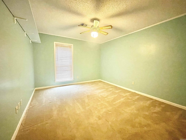 carpeted spare room featuring visible vents, ceiling fan, a textured ceiling, and baseboards