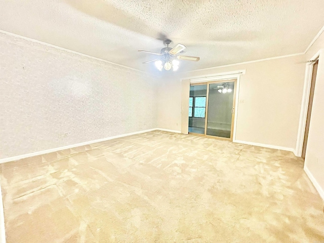 spare room featuring carpet, crown molding, ceiling fan, a textured ceiling, and baseboards