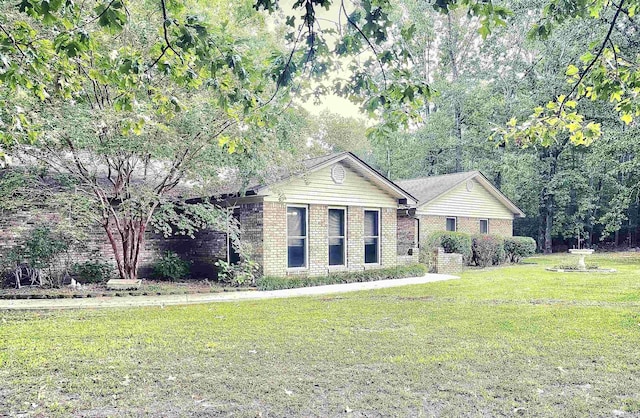 ranch-style home with brick siding and a front lawn