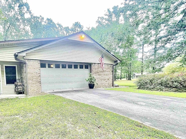 exterior space featuring a lawn, concrete driveway, and brick siding