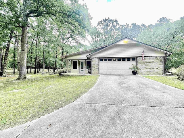 single story home with driveway, an attached garage, a front lawn, and brick siding