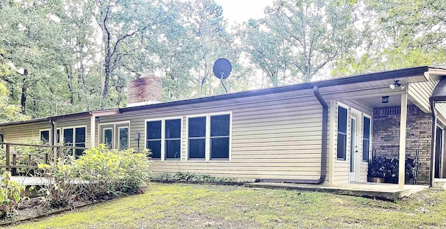 exterior space with a chimney and a yard