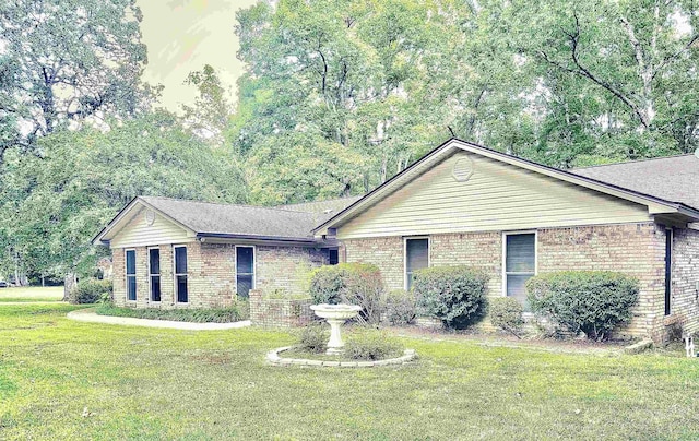 single story home featuring brick siding and a front yard