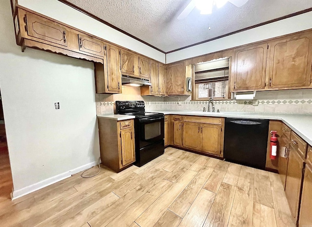 kitchen featuring under cabinet range hood, a sink, decorative backsplash, black appliances, and light wood finished floors