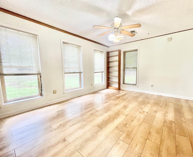 empty room featuring light wood-type flooring, a ceiling fan, visible vents, and a textured ceiling