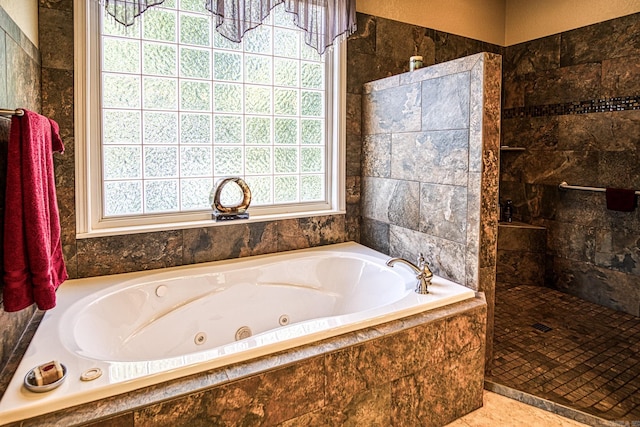 bathroom featuring a wealth of natural light, independent shower and bath, and tile patterned flooring