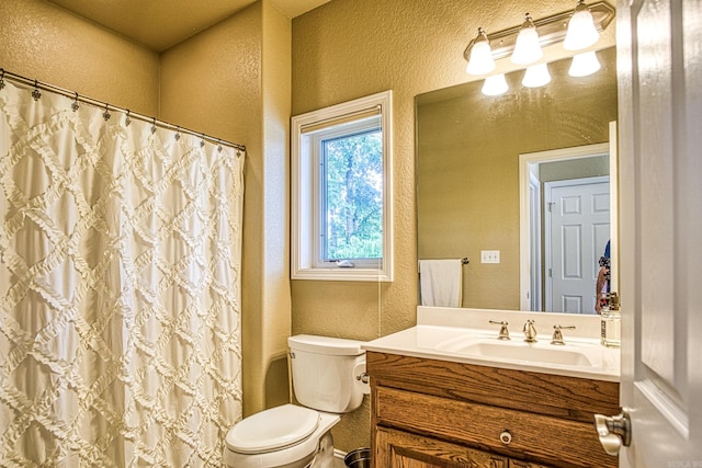 bathroom featuring curtained shower, toilet, and vanity