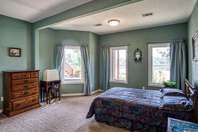 bedroom featuring a textured ceiling and carpet flooring