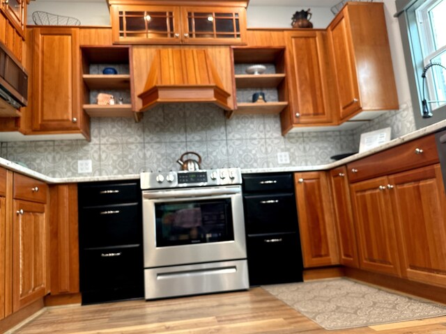 kitchen with backsplash, stainless steel appliances, and light hardwood / wood-style floors