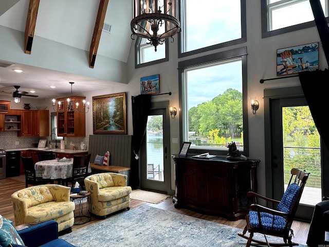 living room with a wealth of natural light and ceiling fan with notable chandelier