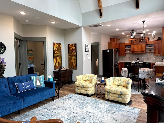 living room with a notable chandelier, sink, and hardwood / wood-style flooring