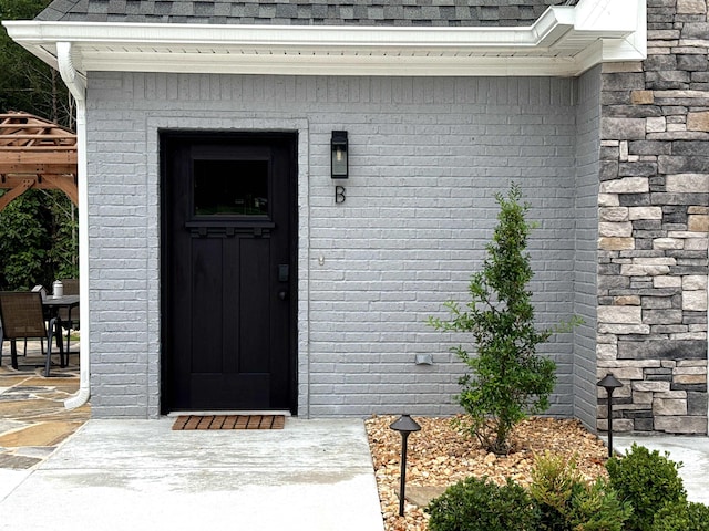 51 Yosemite Dr, Cherokee Village, AR 72529 - view of exterior entry with roof with shingles and brick siding