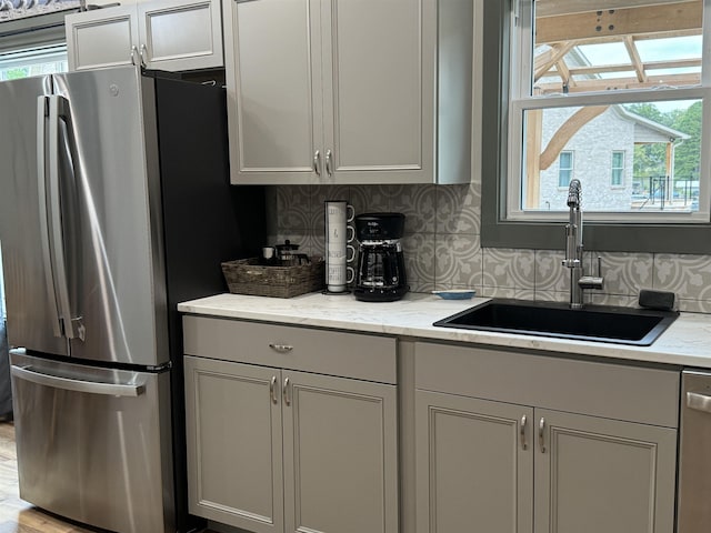 51 Yosemite Dr, Cherokee Village, AR 72529 - kitchen featuring stainless steel appliances, a sink, tasteful backsplash, light stone countertops, and gray cabinetry