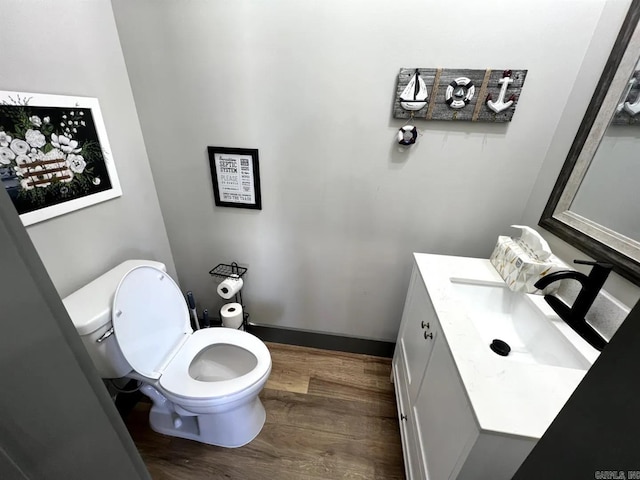 bathroom featuring vanity, toilet, and hardwood / wood-style flooring