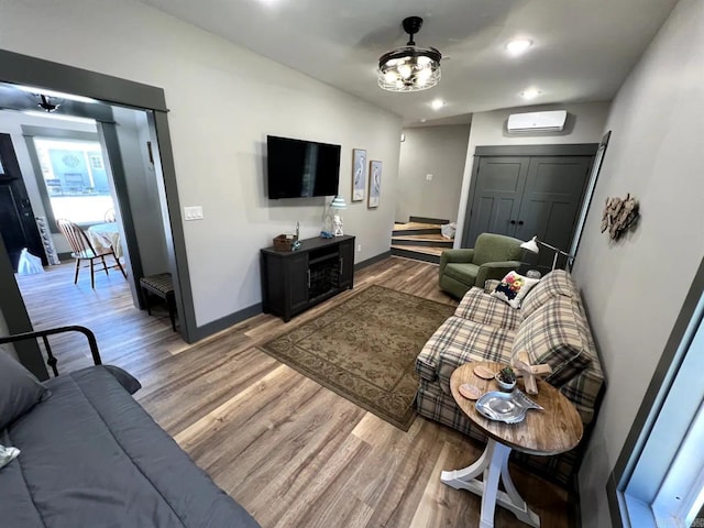 living room with ceiling fan, hardwood / wood-style flooring, and an AC wall unit