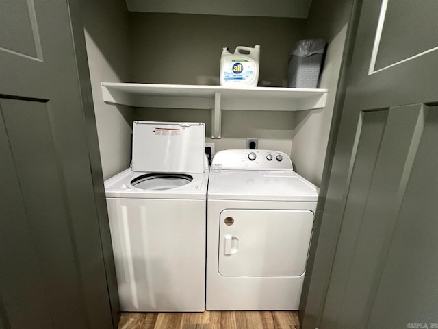 laundry room with light hardwood / wood-style floors and washing machine and clothes dryer