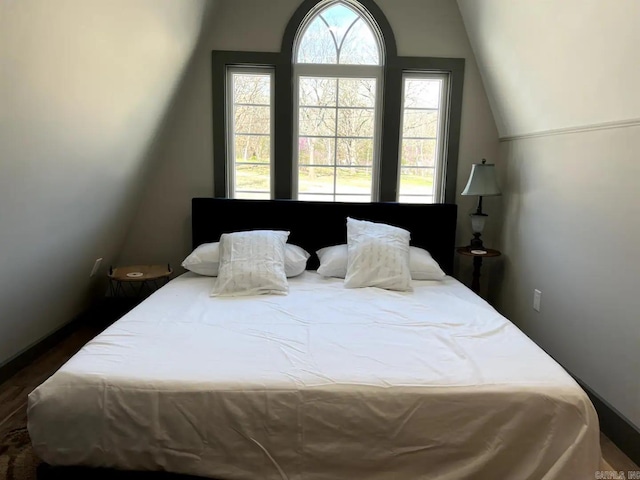 bedroom featuring lofted ceiling and hardwood / wood-style flooring