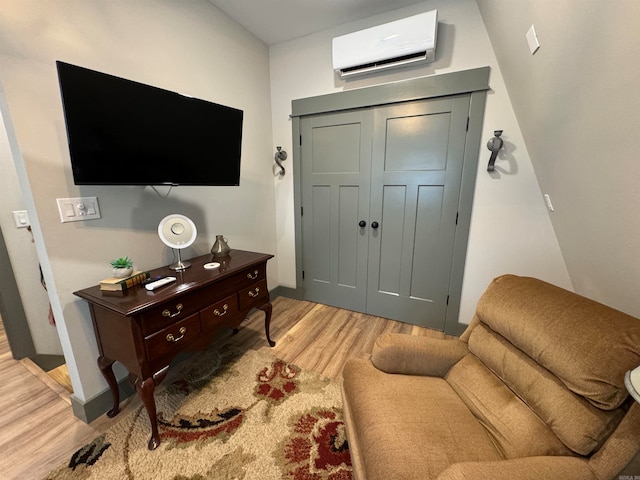 living room with light wood-type flooring and an AC wall unit