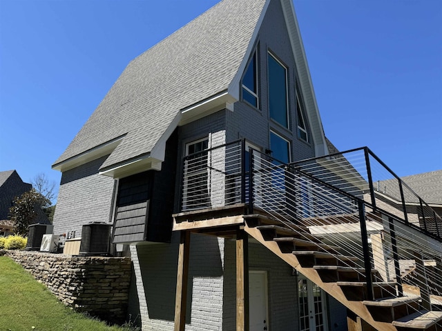 51 Yosemite Dr, Cherokee Village, AR 72529 - view of side of property featuring brick siding, roof with shingles, and central air condition unit