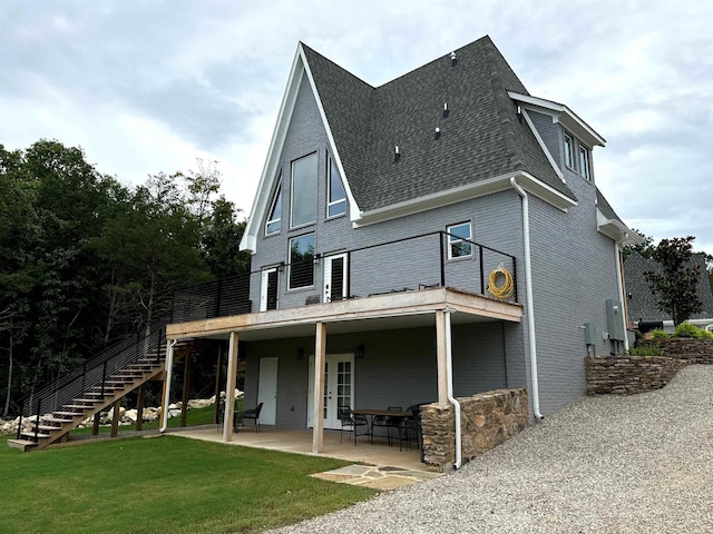 rear view of property with a lawn and a patio