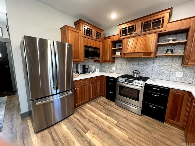 kitchen with stainless steel appliances, tasteful backsplash, and light hardwood / wood-style flooring