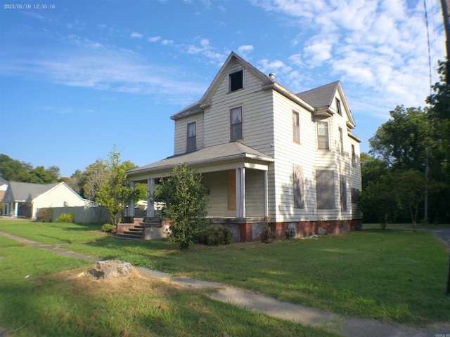 view of side of home with a yard and a porch