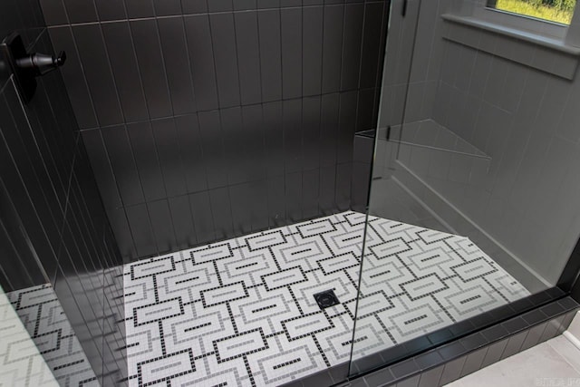 details with tiled shower and tile patterned flooring