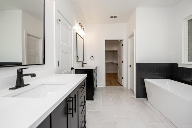 bathroom with vanity, tile patterned flooring, and a washtub