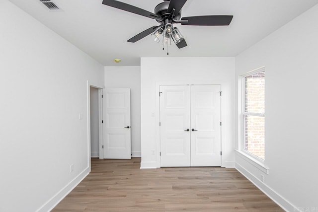 unfurnished bedroom with light hardwood / wood-style flooring, ceiling fan, and a closet