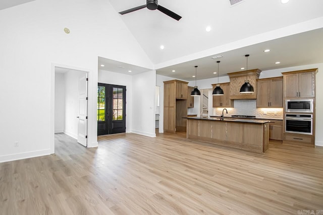 kitchen with hanging light fixtures, stainless steel appliances, light hardwood / wood-style floors, ceiling fan, and high vaulted ceiling