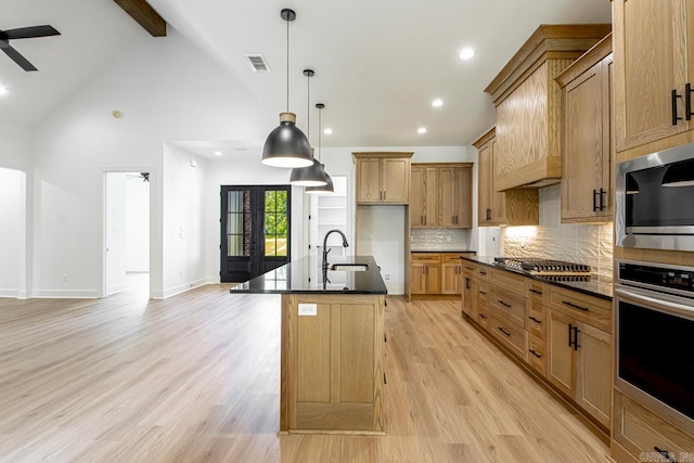 kitchen with light hardwood / wood-style floors, ceiling fan, beamed ceiling, and a kitchen island with sink