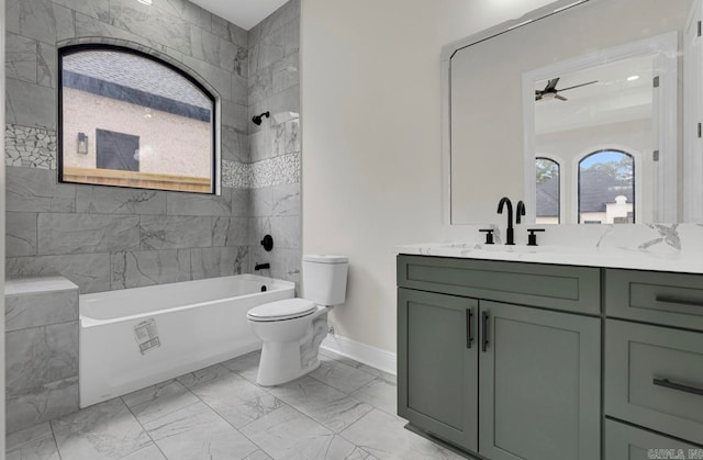 full bathroom featuring vanity, toilet, tiled shower / bath combo, and ceiling fan