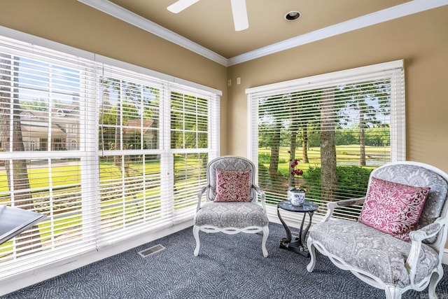 sitting room with ornamental molding, carpet flooring, ceiling fan, and visible vents