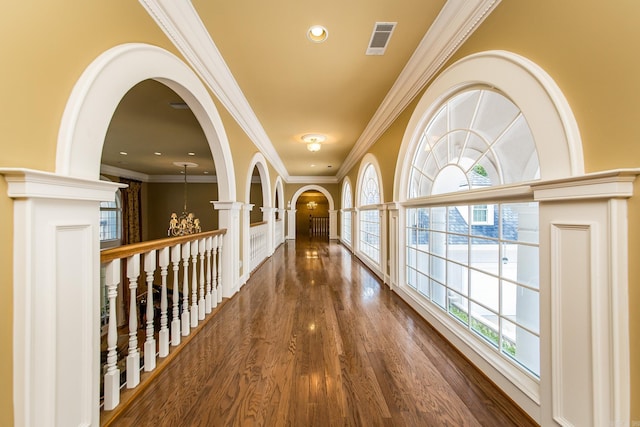 corridor with arched walkways, recessed lighting, visible vents, an inviting chandelier, and wood finished floors