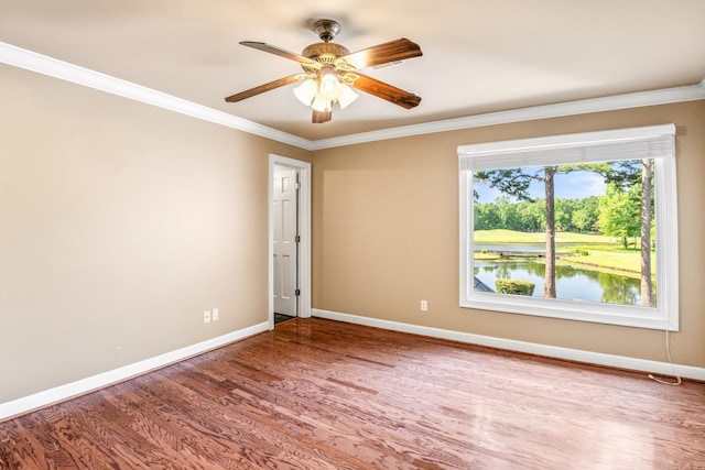 spare room with ornamental molding, a ceiling fan, baseboards, and wood finished floors