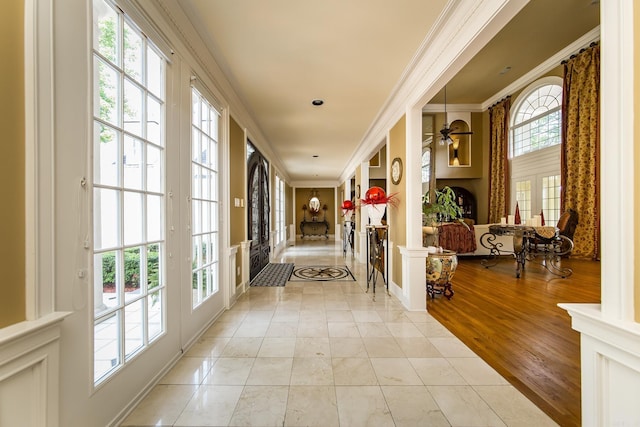 interior space with a healthy amount of sunlight, decorative columns, and crown molding