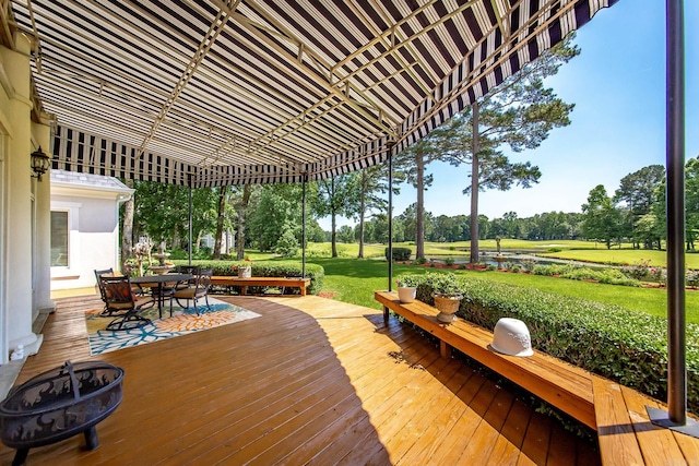 wooden deck with a lawn and outdoor dining space