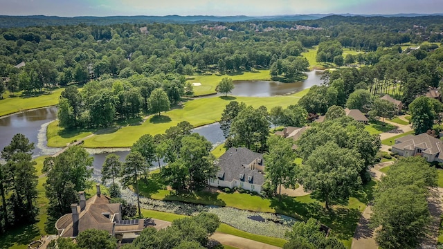 birds eye view of property with view of golf course, a water view, and a view of trees