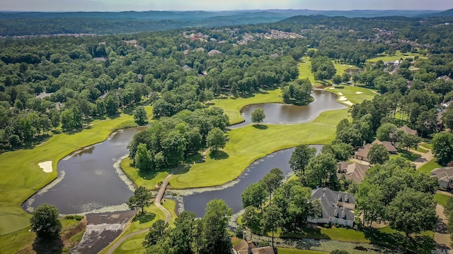 birds eye view of property with a forest view, golf course view, and a water view