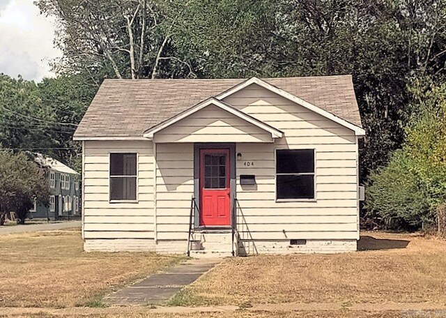 bungalow-style home with a front yard